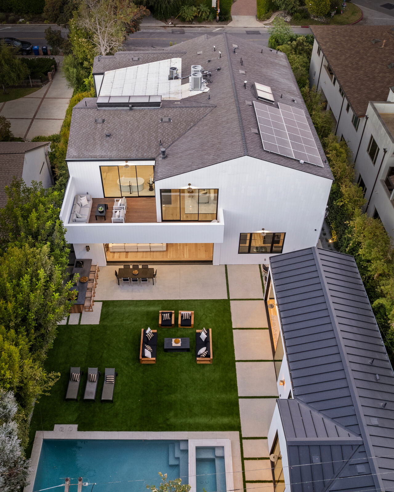 Aerial view of modern San Fernando Valley home with patio and lawn