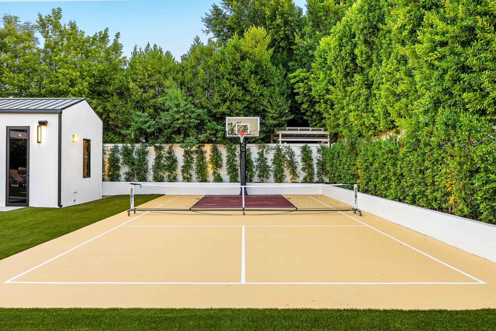 Los Angeles backyard sports court with basketball hoop and pickleball net