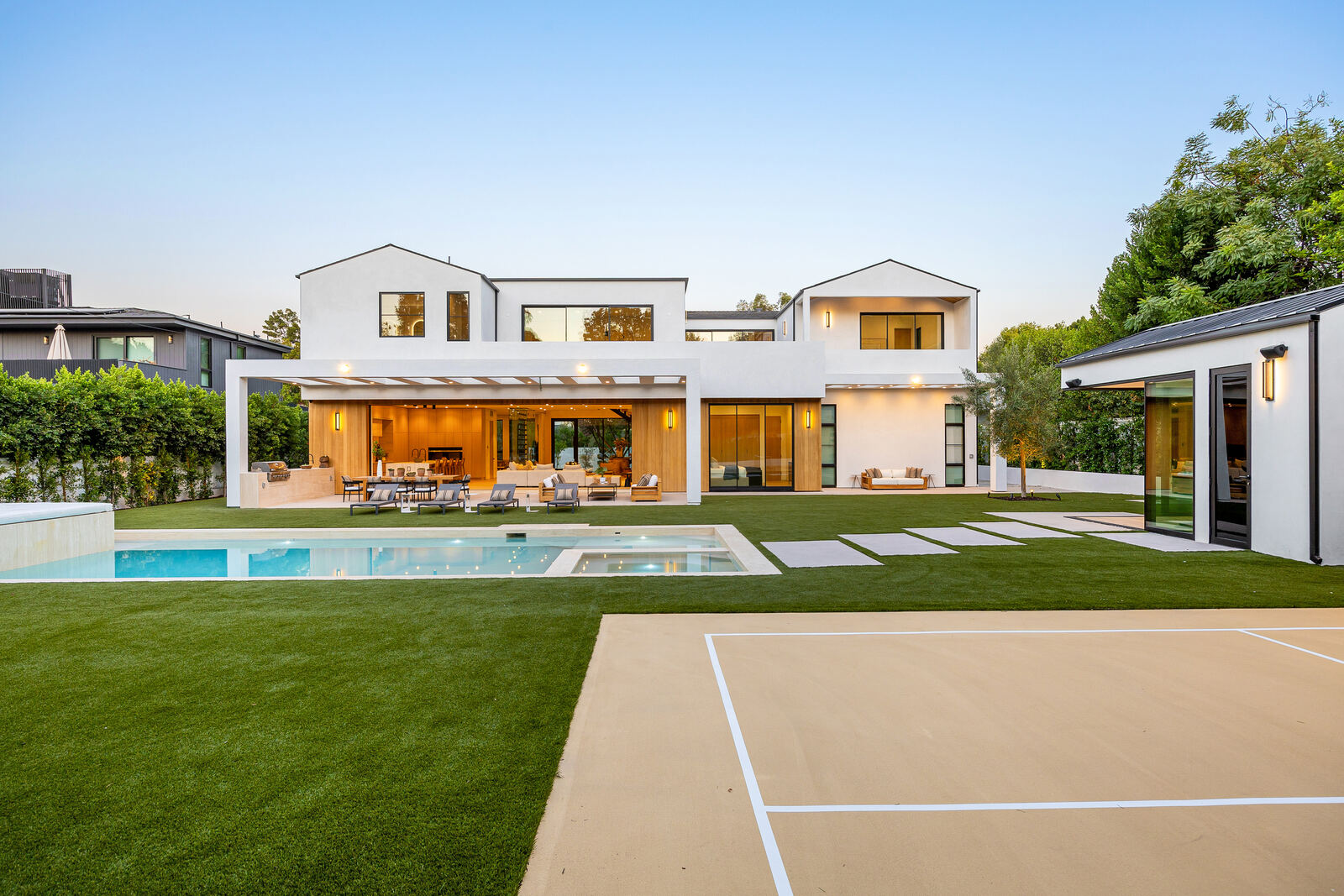 Backyard pool, sports court and covered outdoor kitchen at a Los Angeles home