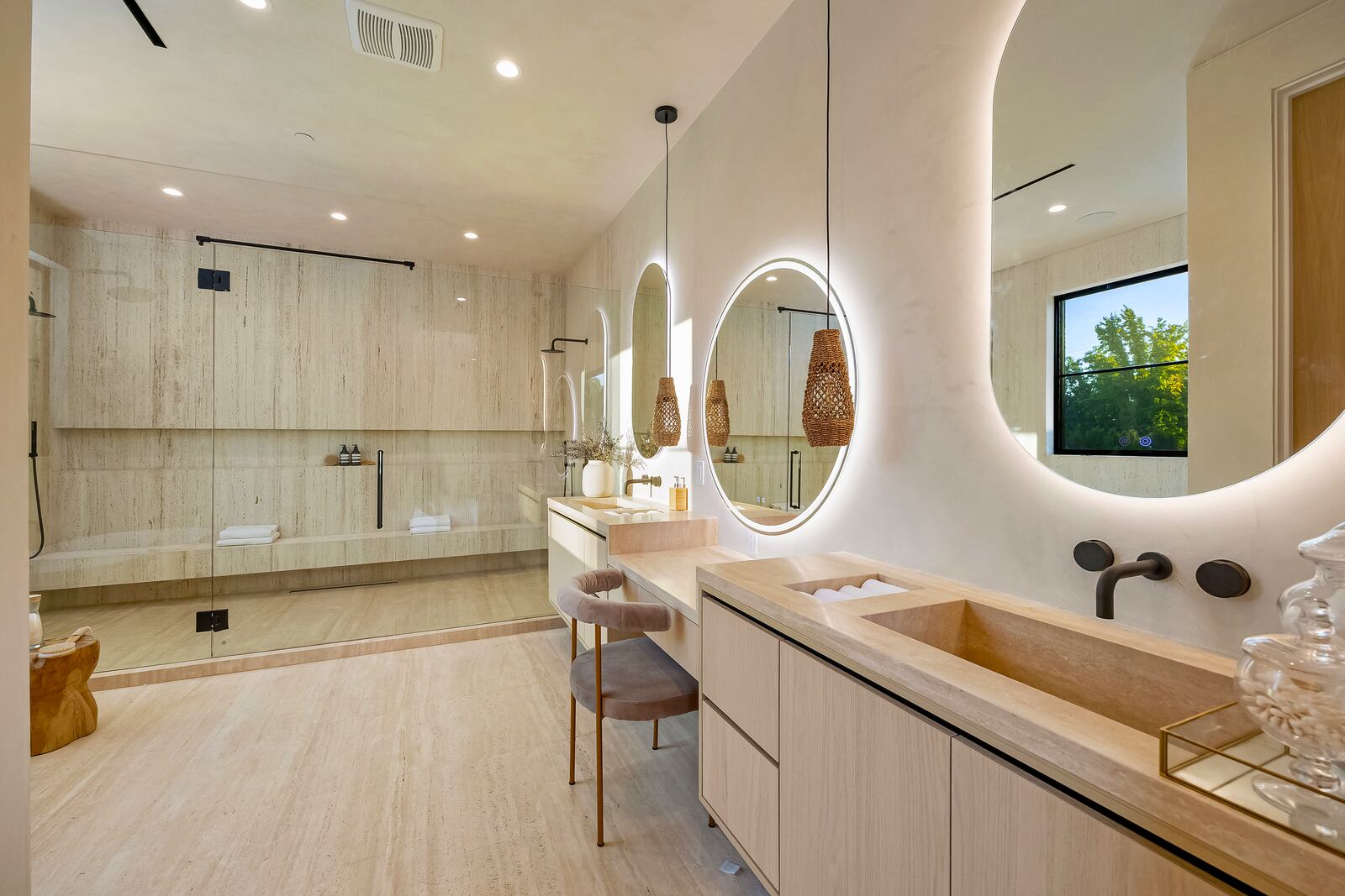 Los Angeles bathroom with double vanity, arched mirrors and glass shower