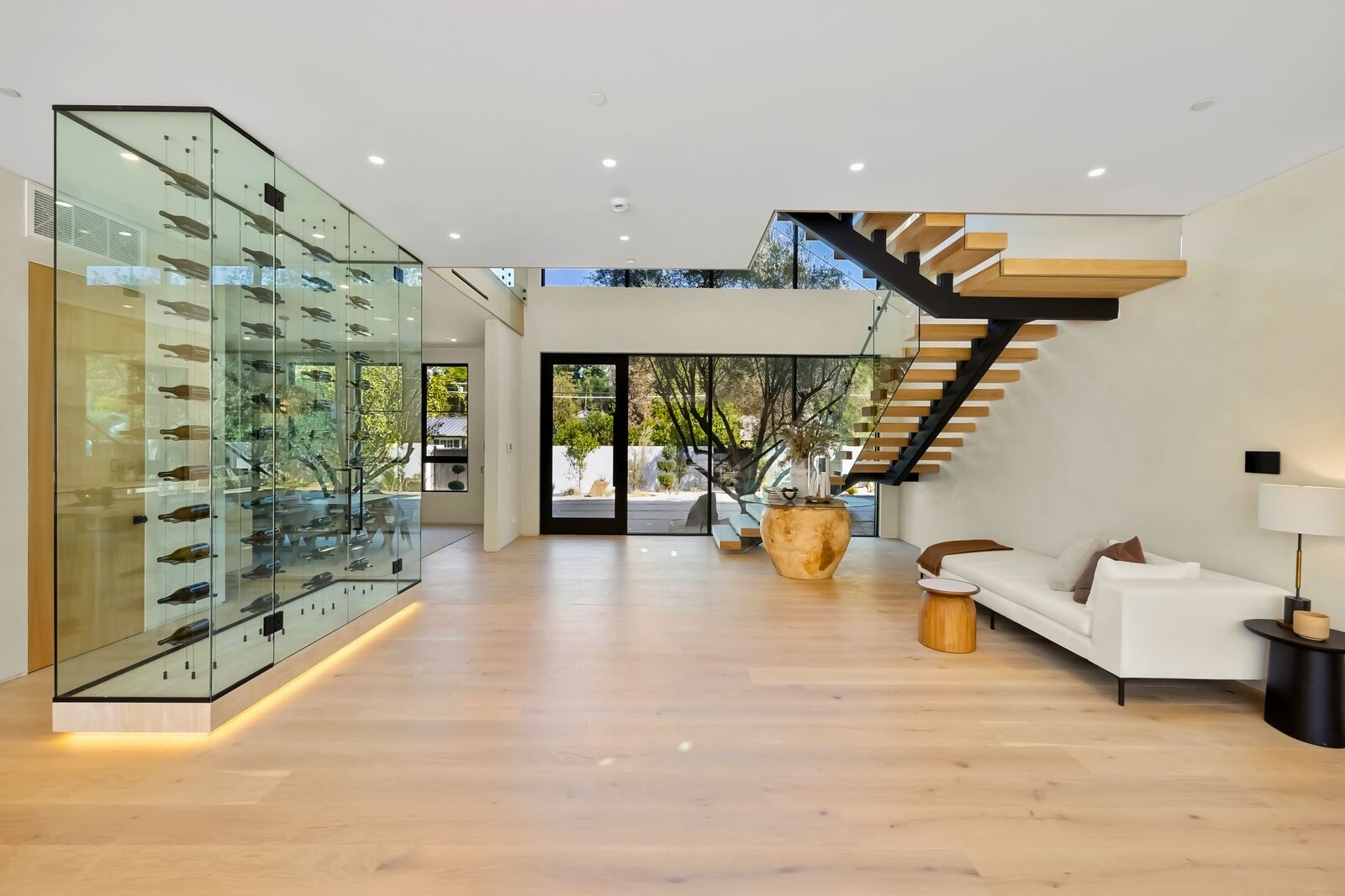 Modern Los Angeles entry with floating staircase and glass wine display