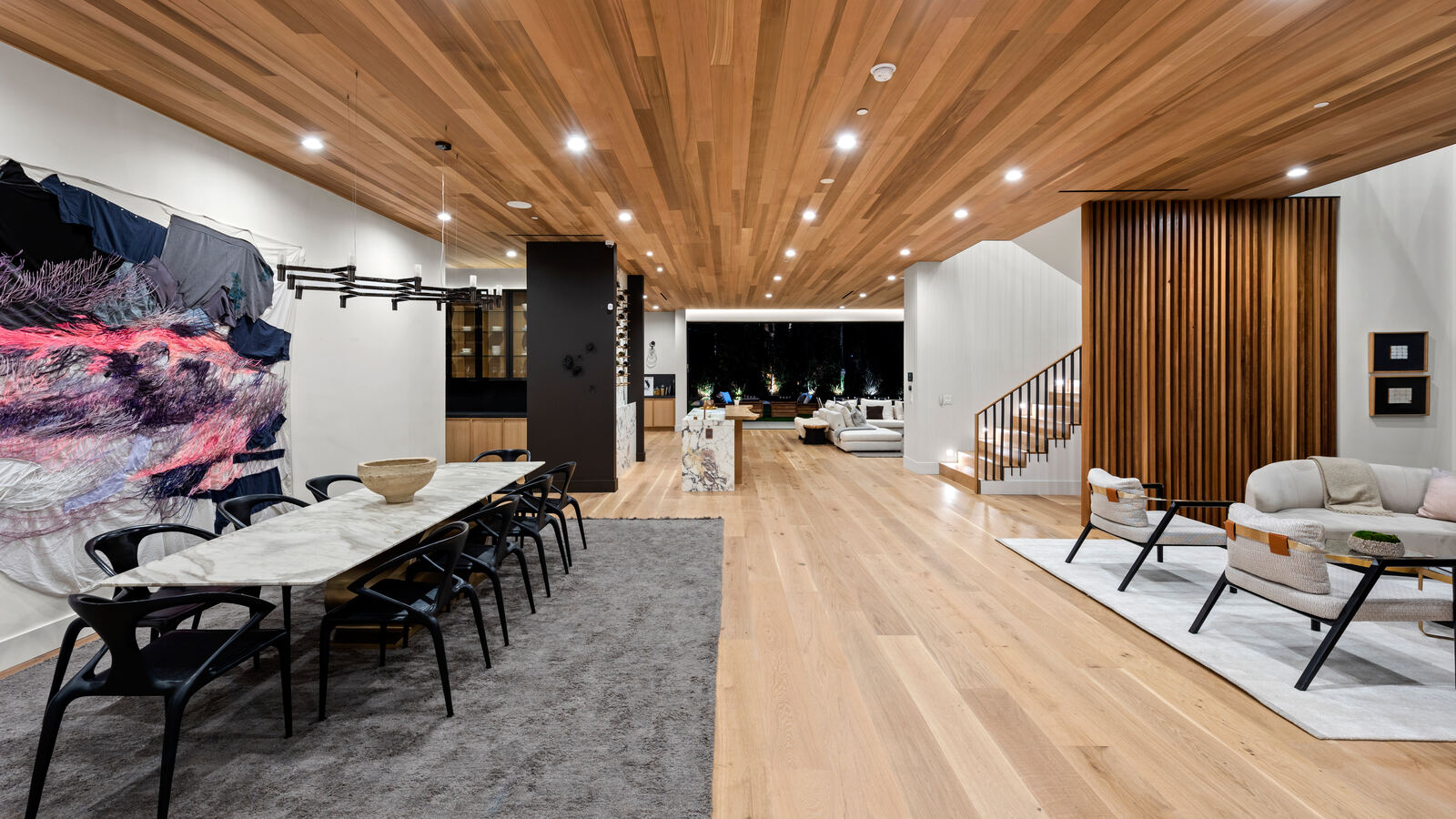 Open-plan Los Angeles interior with dining table, living room and staircase