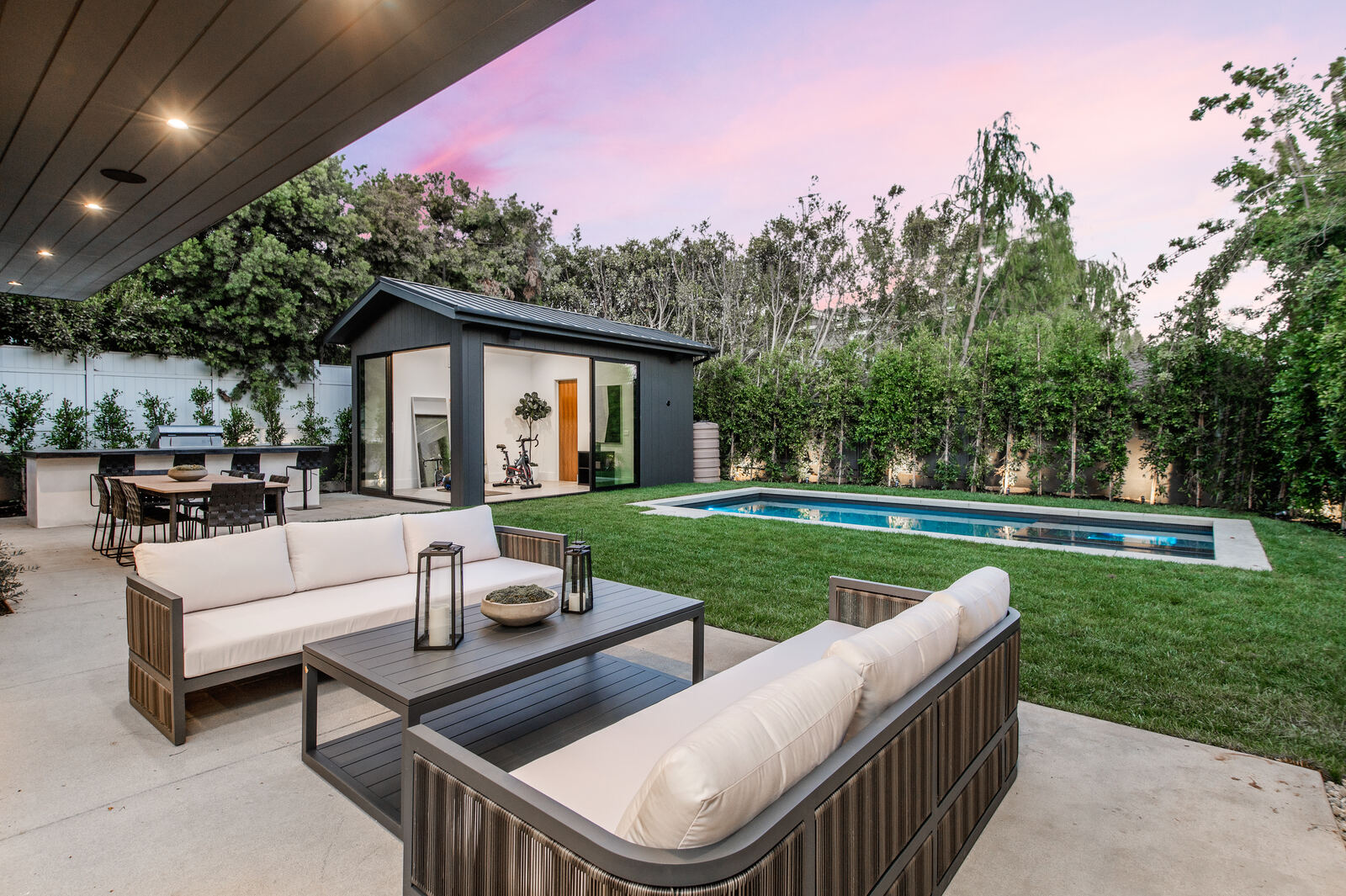 Poolside patio seating facing a guesthouse in Los Angeles