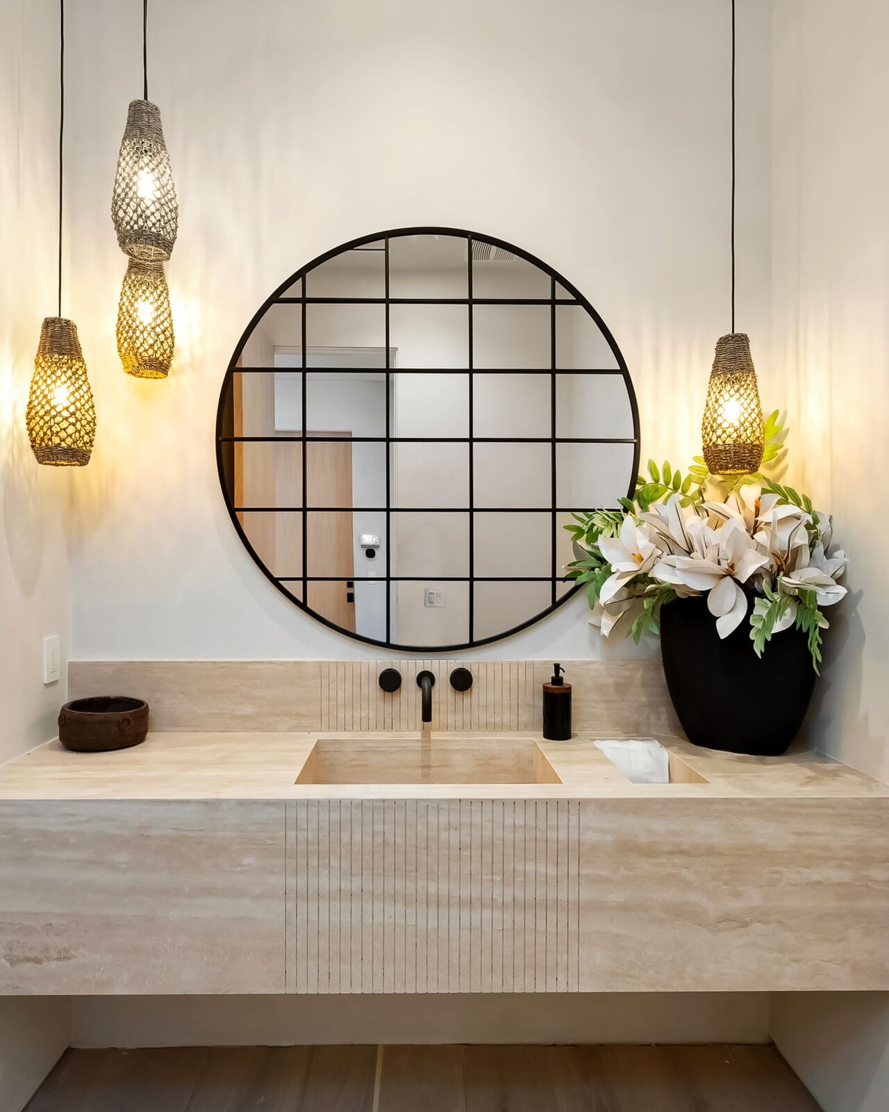 Los Angeles powder room with round mirror, pendant lights and stone vanity